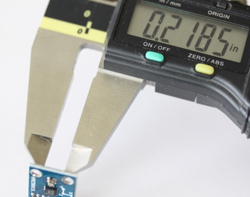 Triple Axis Magnetometer shown with caliper. The measurement reads ..2185 inches (5.55 mm).
