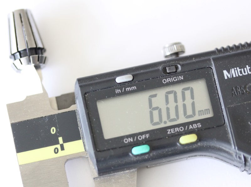 ER11 6mm collet shown with a caliper. The measurement reads 6mm (.023622 inches).